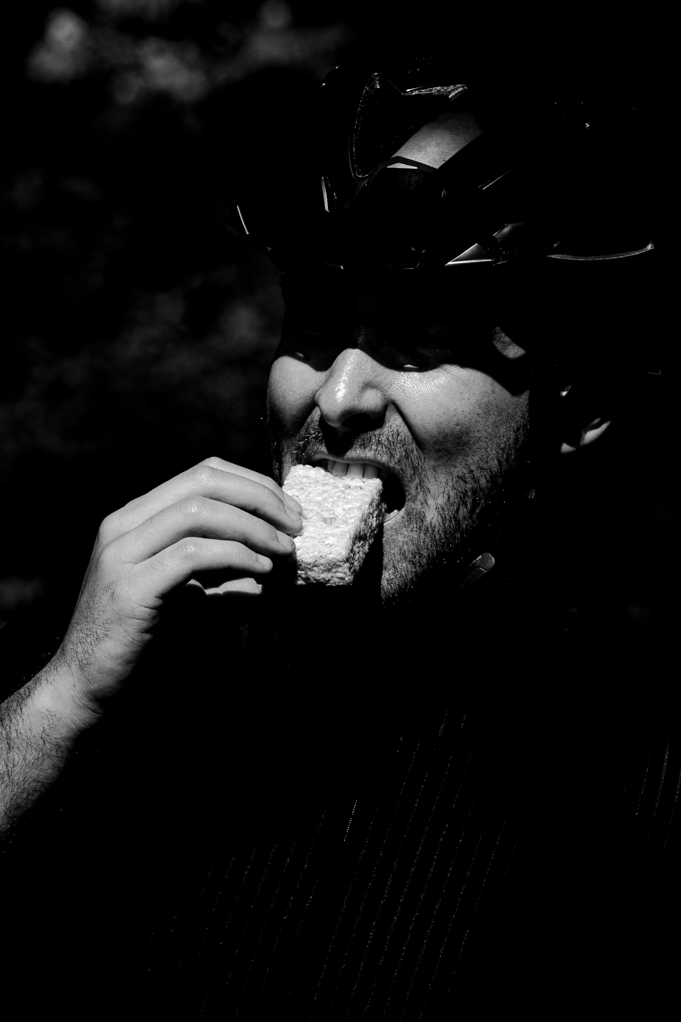 Athlete fueling mid-ride in high contrast