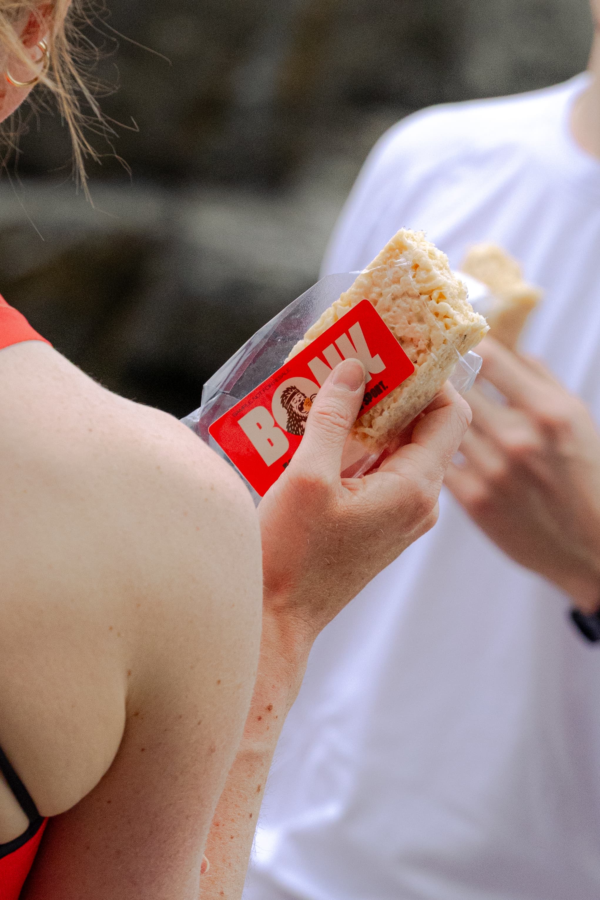 Close up of athlete holding a Bonk bar while running